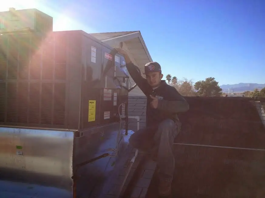 HVAC technician performing AC Tune-Up on a rooftop unit in Redmond